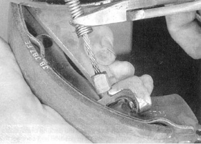 4е. Отсоедините стяжную пружину.